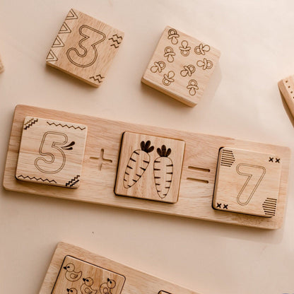 Wooden Two Piece Math Frame by QToys. educational blocks with numbers and arithmetic symbols on a light background